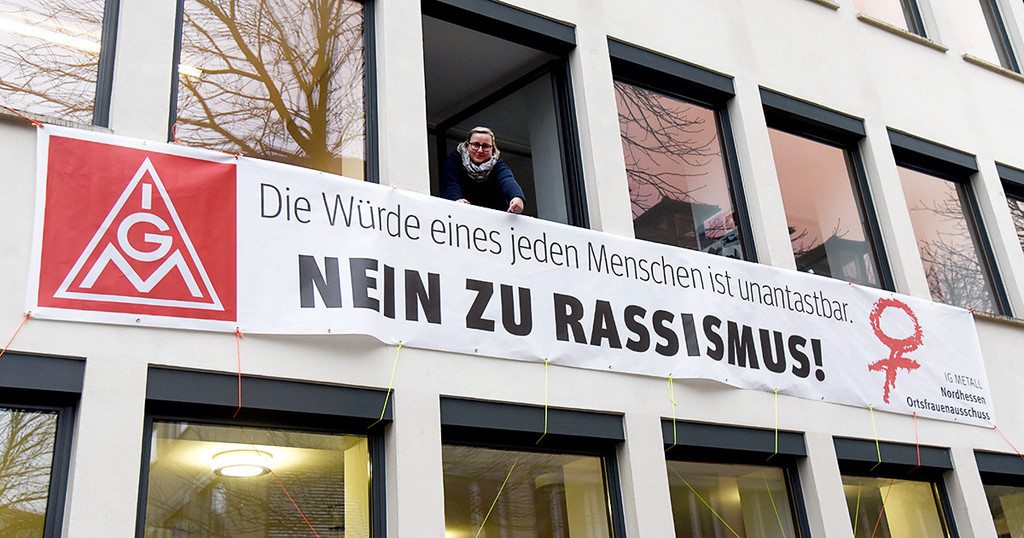 Gewerkschaftssekretärin Anja Neumann zeigt das neue Transparent am DGB-Haus in Kassel. (Foto: Martin Sehmisch)